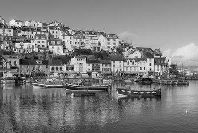 Buildings by sea against sky