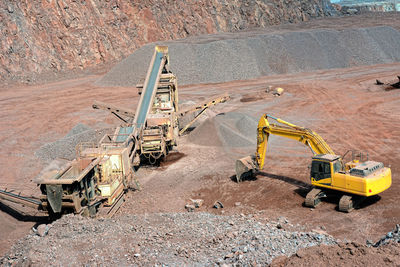 High angle view of earth mover and crusher at construction site