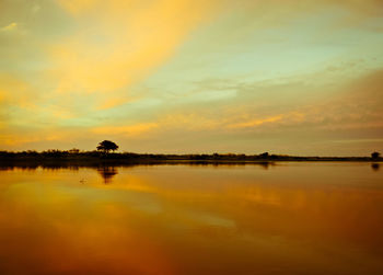 Scenic view of lake against orange sky during sunset