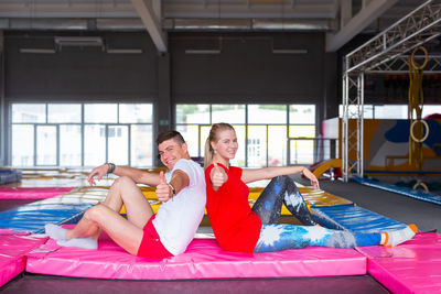 Portrait of happy friends sitting in swimming pool