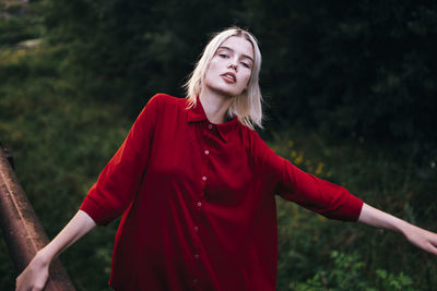 Blonde woman in red shirt on nature