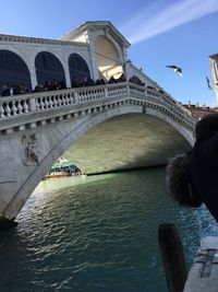 Arch bridge over river against sky