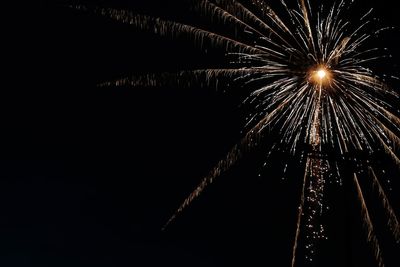 Low angle view of fireworks against sky at night