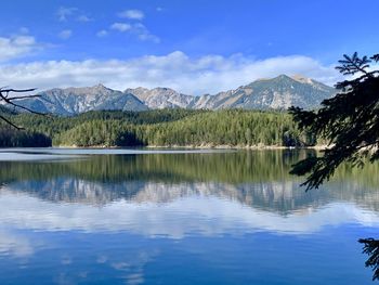 Scenic view of lake and mountains against blue sky