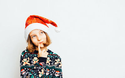 Portrait of young woman standing against white background