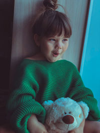 Cute girl with stuffed toy making face at home