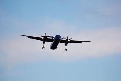 Low angle view of airplane flying against sky