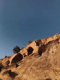 Low angle view of rock formations against clear blue sky