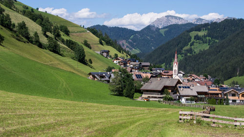 Scenic view of field and houses against mountains
