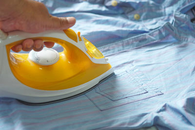 Close-up of hand holding yellow table