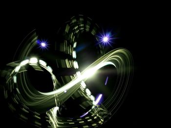 Illuminated ferris wheel against black background