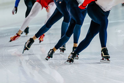 Low section of people walking on snow