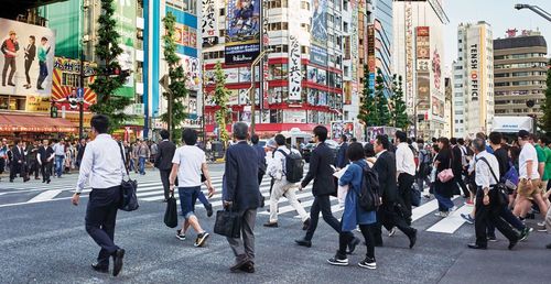 Group of people walking on road along buildings