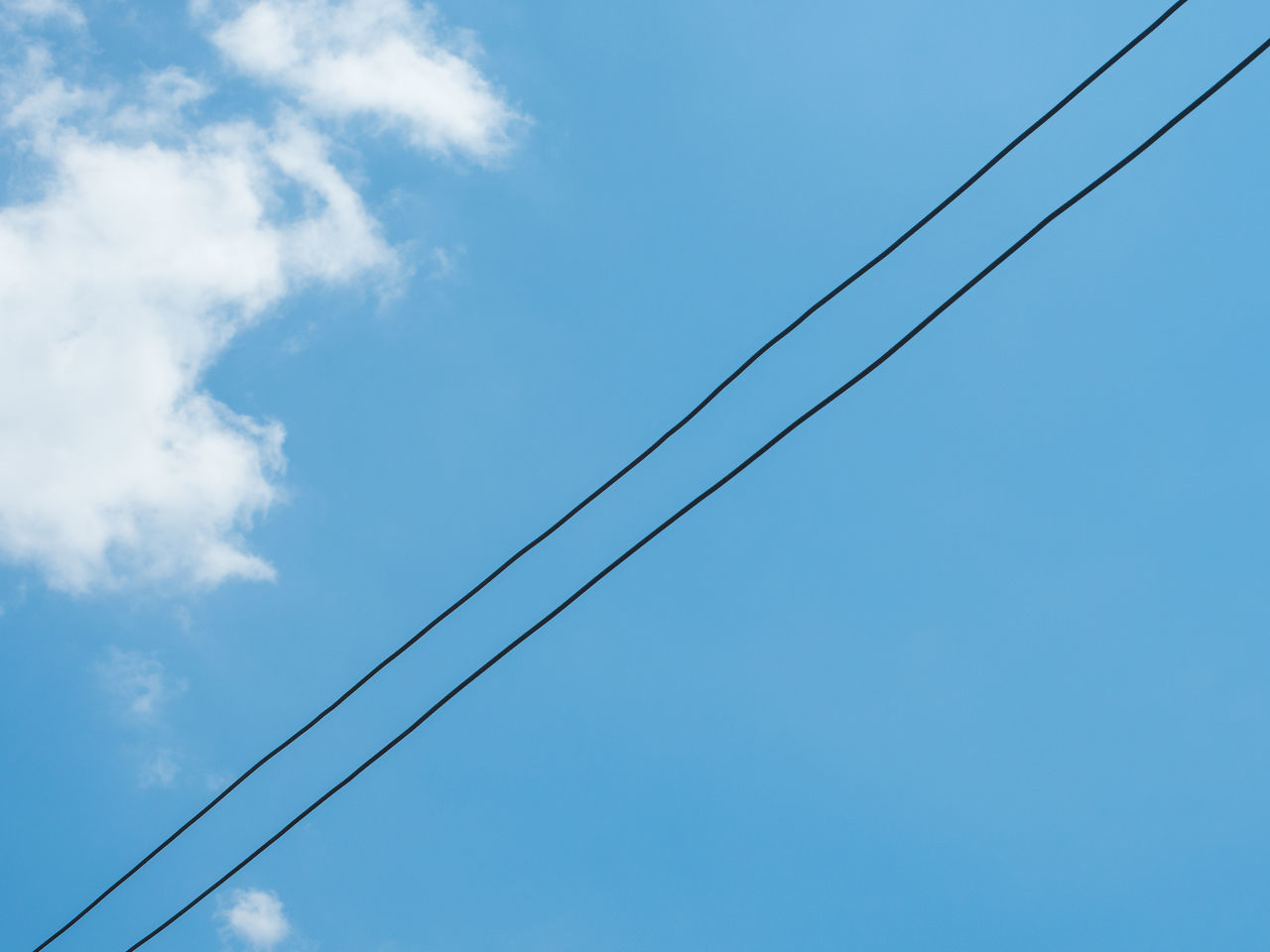 LOW ANGLE VIEW OF POWER CABLES AGAINST SKY