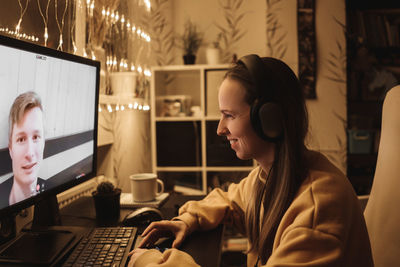 Side view of woman video calling at home