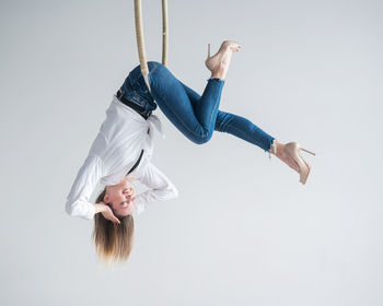 Caucasian woman gymnast on an aerial hoop takes a selfie on a smartphone. 