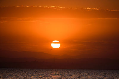 Scenic view of sea against romantic sky at sunset