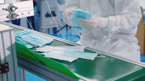 Midsection of man wearing protective suit working in factory