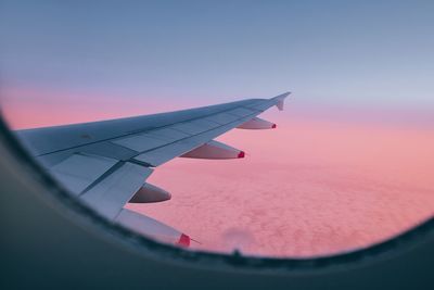 Airplane flying against clear sky during sunset