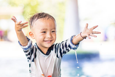 Portrait of happy boy with arms raised