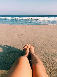 Low section of woman relaxing at beach