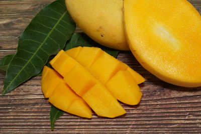 High angle view of yellow lemon and leaves on table