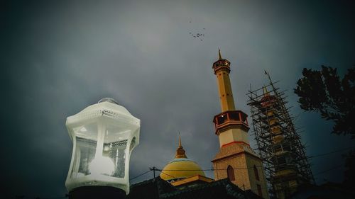 Low angle view of bell tower against sky at dusk