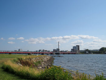 Scenic view of city by sea against sky