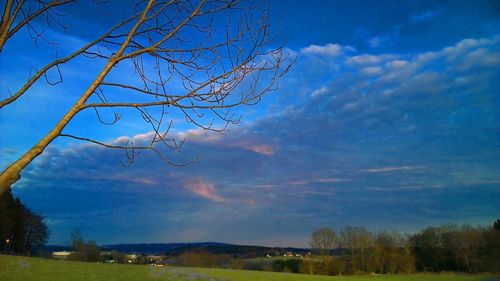 Scenic view of field against cloudy sky