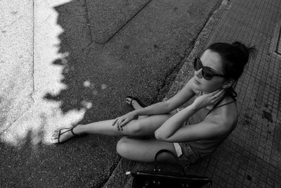 High angle view of girl sitting in sunglasses