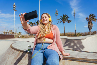 Woman taking selfie through smart phone