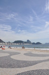 People on beach against sky