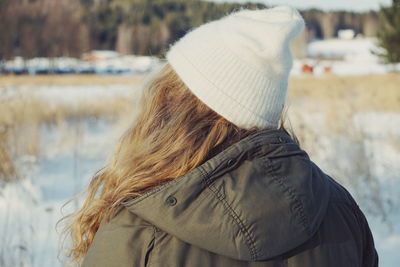 Rear view of woman standing outdoors during winter