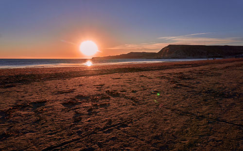 Scenic view of beach against sky during sunset