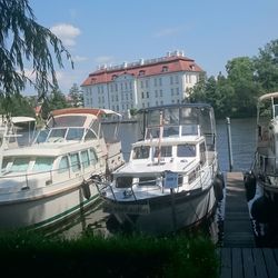 Boats moored on lake in city against clear sky