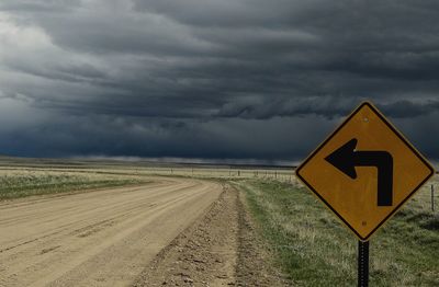 View of road sign against cloudy sky