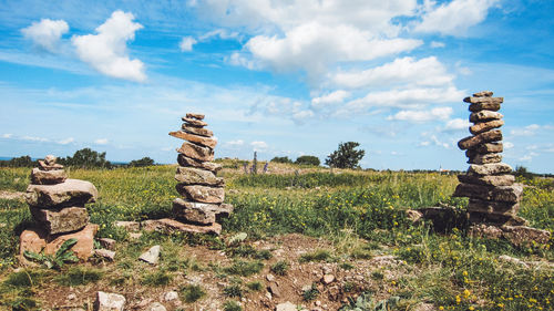 Stone stack on field against sky