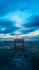 Bench on promenade against sea