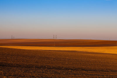 Scenic view of field against clear sky during sunset