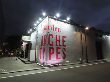 Information sign on road in city at night