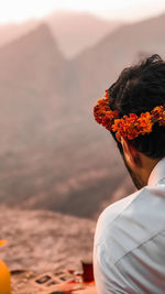 Rear view of woman with flowers on mountain