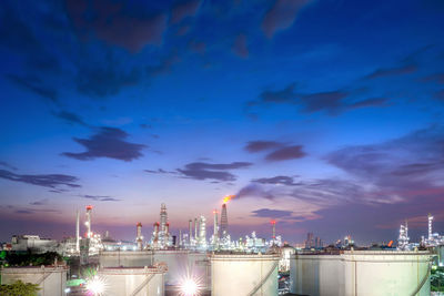 Illuminated city against sky at dusk