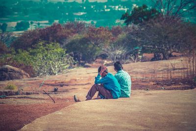 Rear view of couple sitting in park