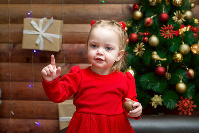 Portrait of cute girl playing with christmas tree