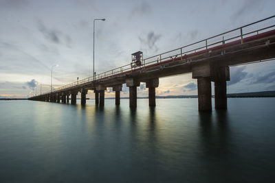 Low angle view of bridge over river against sky