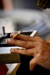 Close-up of hand holding cigarette