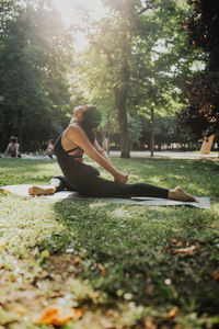 Yoga instructor practicing ardha kapotasana in park