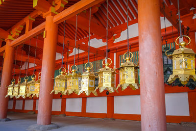 Low angle view of illuminated lanterns hanging in temple building