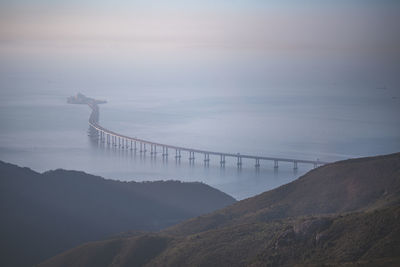 View of bridge over sea against cloudy sky