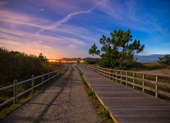 Empty footpath against sky during night